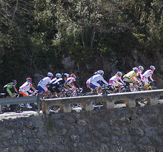 Eine kleine Radfahrgruppe auf einer steinernen Brücke während des La Mussara-Events.